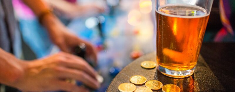 Couple Playing Arcade Games with Beer in Foreground