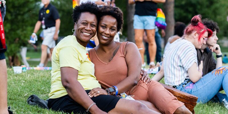 Two women embracing each other on the lawn for KC Pride festival.