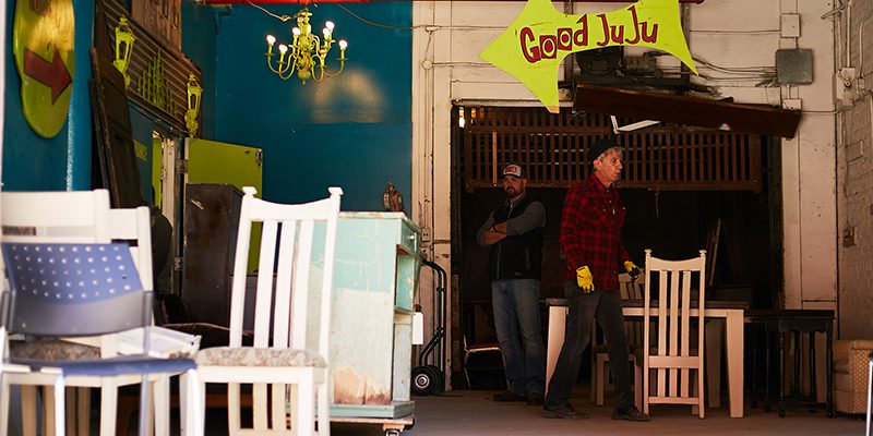 Vintage wooden chairs outside of a store with a sign that reads Good JuJu